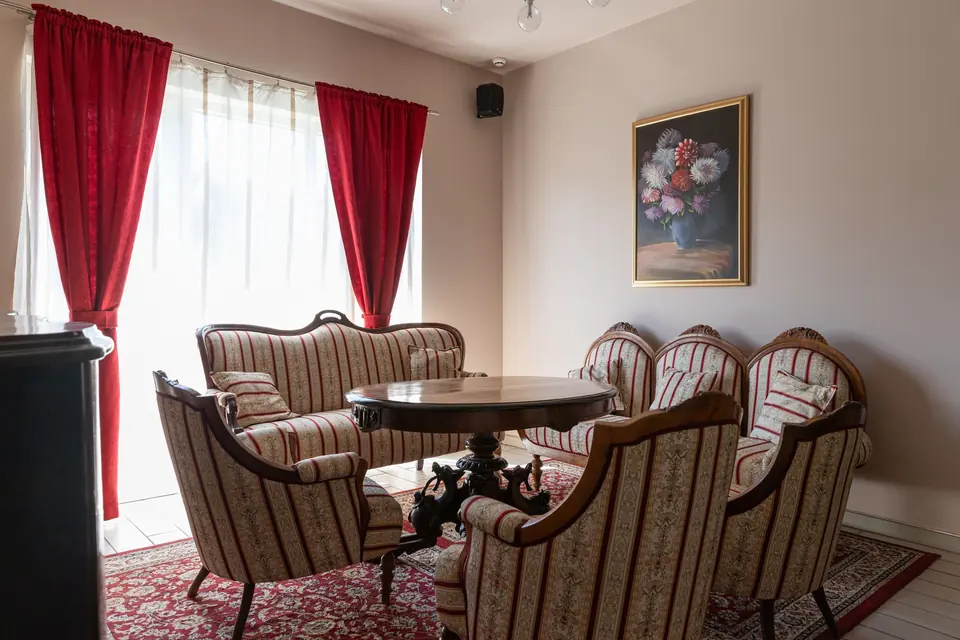 Soba Čaplja s prugastim foteljama i crvenim zavjesama